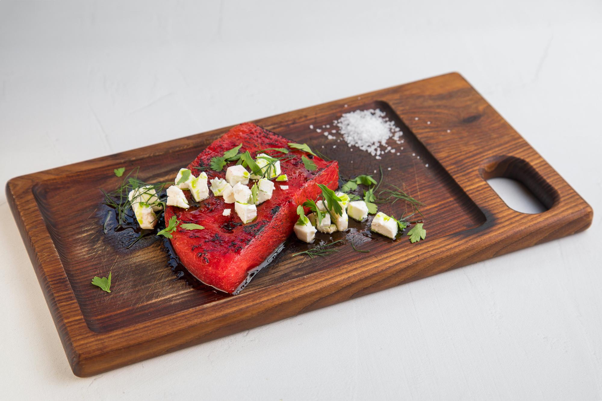 Large plated dish on wooden board, editorial crop
